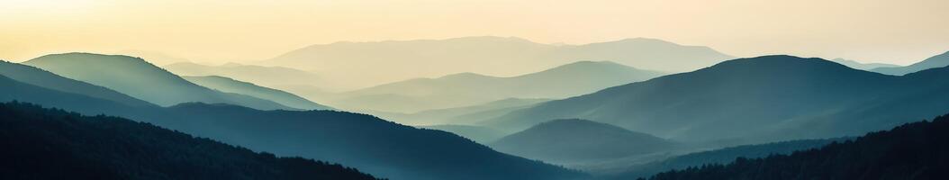 Foggy mountain landscape at dusk with layered hills in the distance photo