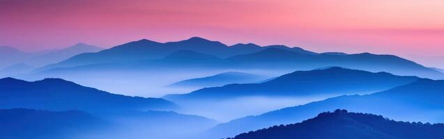 Evening fog envelops mountains under a soft pastel sky photo