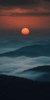 Evening fog envelops mountains under a vibrant sunset sky photo
