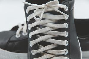 shoe sneaker on white background, close up of sneaker on white background, old black generic sneakers on white background. photo