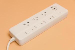 Electrical plug in outlet socket at home, Electrical plug in outlet socket at home, Energy efficiency concept, Power strip with extension cord on beige background, top view. photo