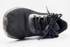 shoe sneaker on white background, close up of sneaker on white background, old black generic sneakers on white background. photo
