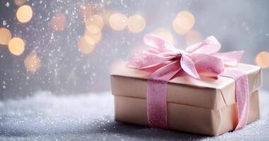 in stunning 4K resolution captures a beautifully wrapped gift box with a pink ribbon, set against a festive backdrop featuring pine branches and twinkling lights video