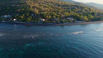Panorama of coastline with quiet ocean and evening sunlight at North Bali, drone view video