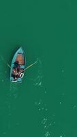 aéreo barco en el lago. aéreo ver en dos hombres en un barco en un lago, remado a el costa. solitario barco en el medio de el río, lago video