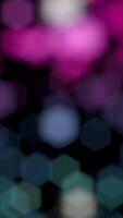 Abstract background of moving bokeh on black background. Animation. Blurred round particles move in black space. Multicolored defocused particles video