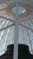 Beautiful domed structure. Stock footage. White air beams in dome structure. Top view of domed circus building on background blue sky video