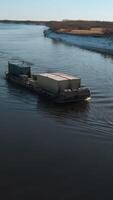River tow pusher with barge. Clip. Top view of barge floating with cargo on river. River barge pusher picturesquely floats on background of horizon on sunny day video