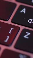 Close up of buttons on computer keyboard, macro background. Action. Black modern laptop buttons under the red lamp light, concept of technologies and devices. video