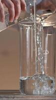 Male researcher carrying out scientific research in a lab. Flasks with liquids in a lab. Liquid in the flask changes color video