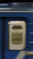 Blue subway train with people inside picking up speed, view from metro station. Close up for windows of subway train passing fast at underground station. video
