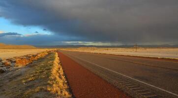Roads during a red sunset and thunderclouds against the backdrop of the Guadalupe Mountains in New Mexico photo
