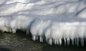 Iced rocks and stones near the shore in the Black Sea at the end of winter photo