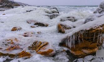 Frozen Black Sea, ice-covered and frozen coastal rocks in the piers, harsh winter photo