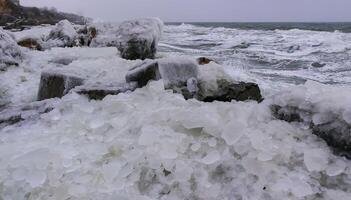 Frozen Black Sea, ice-covered and frozen coastal rocks in the piers, harsh winter photo