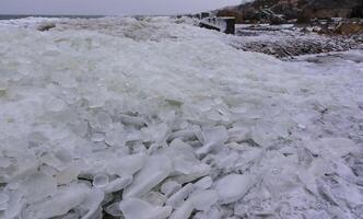 The Black Sea is frozen, the circular ice rolled by the waves is thrown ashore and frozen photo