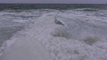 The Black Sea is frozen, the circular ice rolled by the waves is thrown ashore and frozen photo