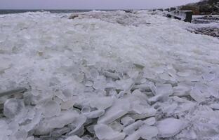 The Black Sea is frozen, the circular ice rolled by the waves is thrown ashore and frozen photo