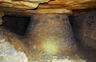 Fortifications in the form of round pear-shaped pillars made of saw shell rock in the Odessa catacombs photo