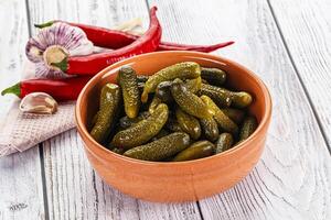 Marinated small cucumbers in the bowl photo