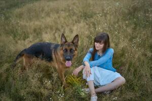 a woman in a Whimsical Aesthetic style dress with a German shepherd in a field photo