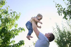 a father plays with a toddler on his shoulders photo