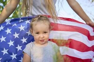 a toddler with american flag on independence day picnic photo