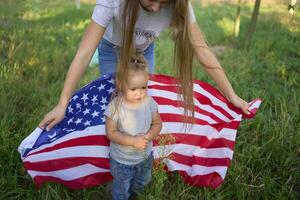 a toddler with american flag on independence day picnic photo
