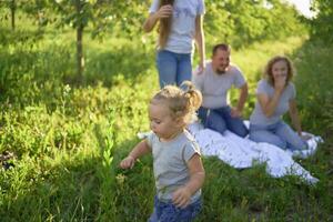 toddler screams and cries in front of family on picnic in garden photo