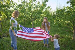 family on independence day picnic with american flag photo