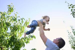 a father plays with a toddler on his shoulders photo