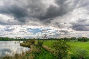 Leuven from the bird watching lookout tower, intensive sky reflecting in the water photo