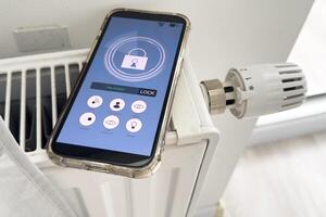 Adjusting Temperature Of Digital Smart Thermostat Using Mobile Phone App At Home photo