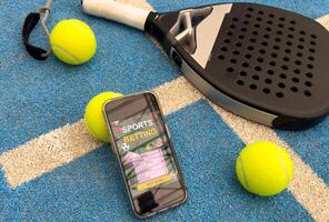padel tennis racket and smartphone with betting photo