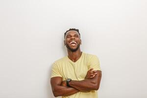 Joyful Man Laughing With Arms Crossed Against a Plain Wall in Natural Light photo