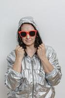 Woman Wearing Silver Jacket and Red Sunglasses Posing Against White Background photo