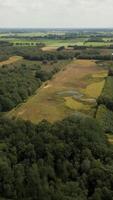 an aerial view of a large field with trees and a pond video