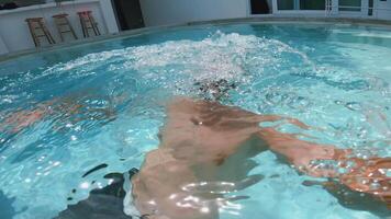 homem dentro óculos mergulhos para dentro a piscina e filmes ele mesmo enquanto relaxante em uma verão Férias dentro tropical país. pessoa apreciar ativo lazer dentro a hotel natação piscina em Férias em uma quente verão dia video