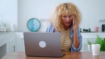 Overworked multitasking busy Caucasian woman freelancer, entrepreneur, copywriter, journalist taking phone call and typing text on laptop at the same time while working on new project, typing report video