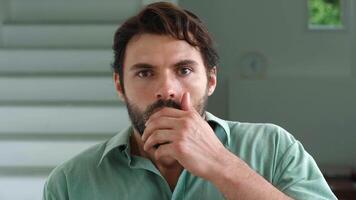 Portrait of a handsome Caucasian bearded man attentively, looking into the camera and sharply covering his mouth with his hand, frightened by what he saw and experiencing a sense of fear and fright. video