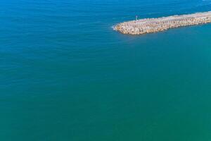 drone aerial view of a harbor breakwater on a calm sea day, summer time photo