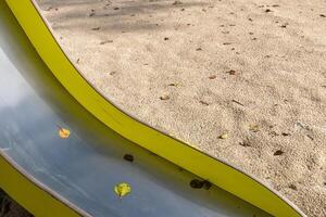 detail of a yellow slide in a playground in fall photo