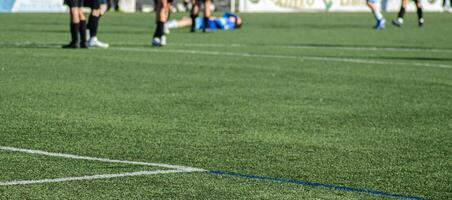 selective focus, view of a soccer field during a match with a player lying on the ground out of focus in the background. sports medicine photo