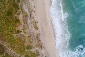 Aerial top view of beautiful tropical white sand beach with wave foam and transparent sea, Summer vacation and Travel background with copy space, Top view from drone photo