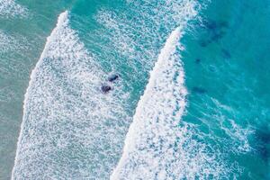 drone top view of seawater foam on the shore of a beach, summer background texture photo