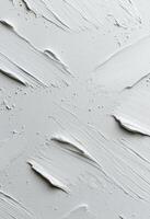 Textured white surface with paint strokes and uneven spots in natural light photo