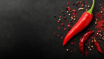 Fresh red chilies with assorted spices on a dark rustic background photo