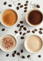 Three cups of coffee with ground coffee beans on a white surface and green leaves in the background photo