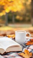 Cozy autumn afternoon with a book and a warm drink among fallen leaves photo