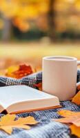 Cozy autumn afternoon with a book and a warm drink among fallen leaves photo
